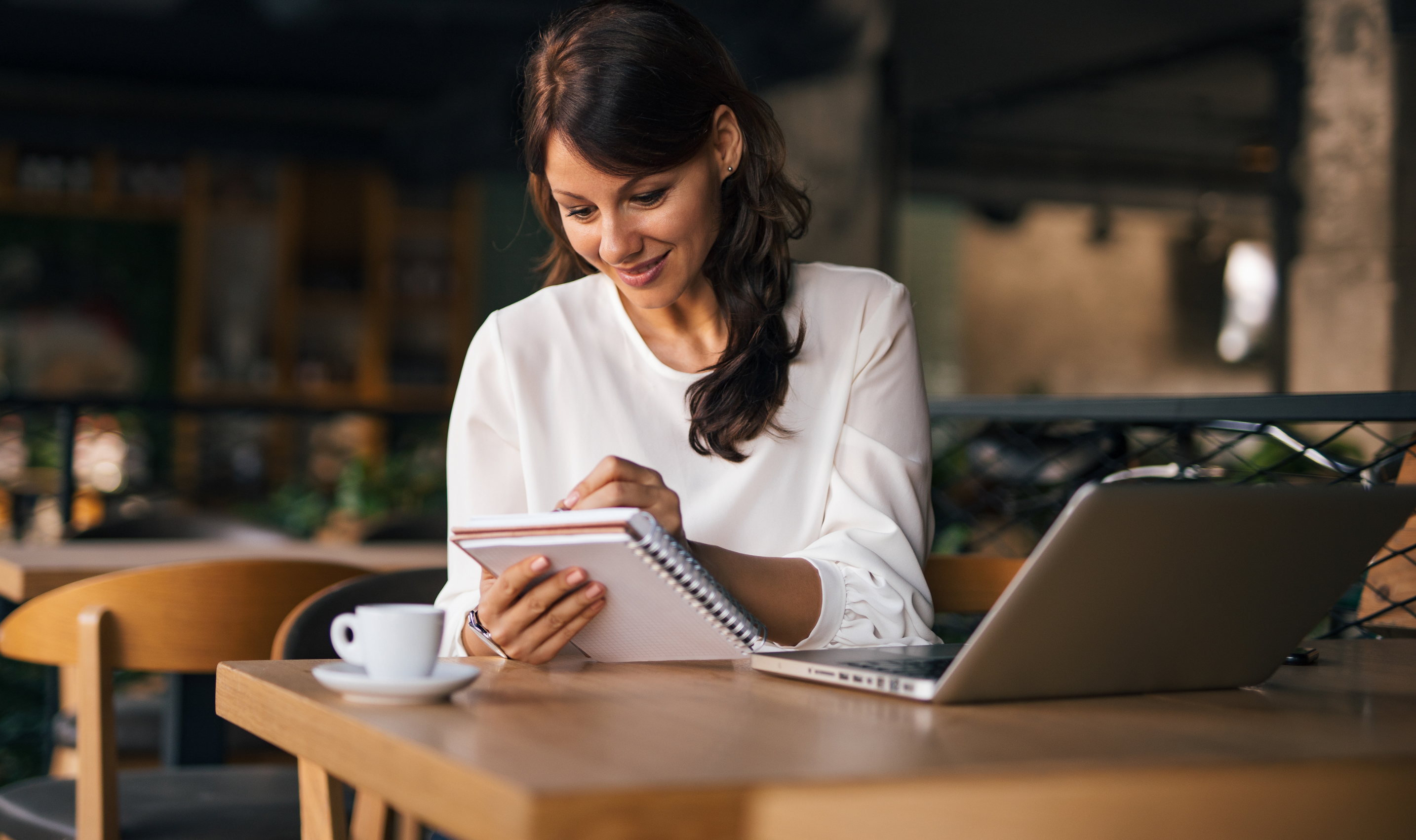 A woman who is writing on a notebook