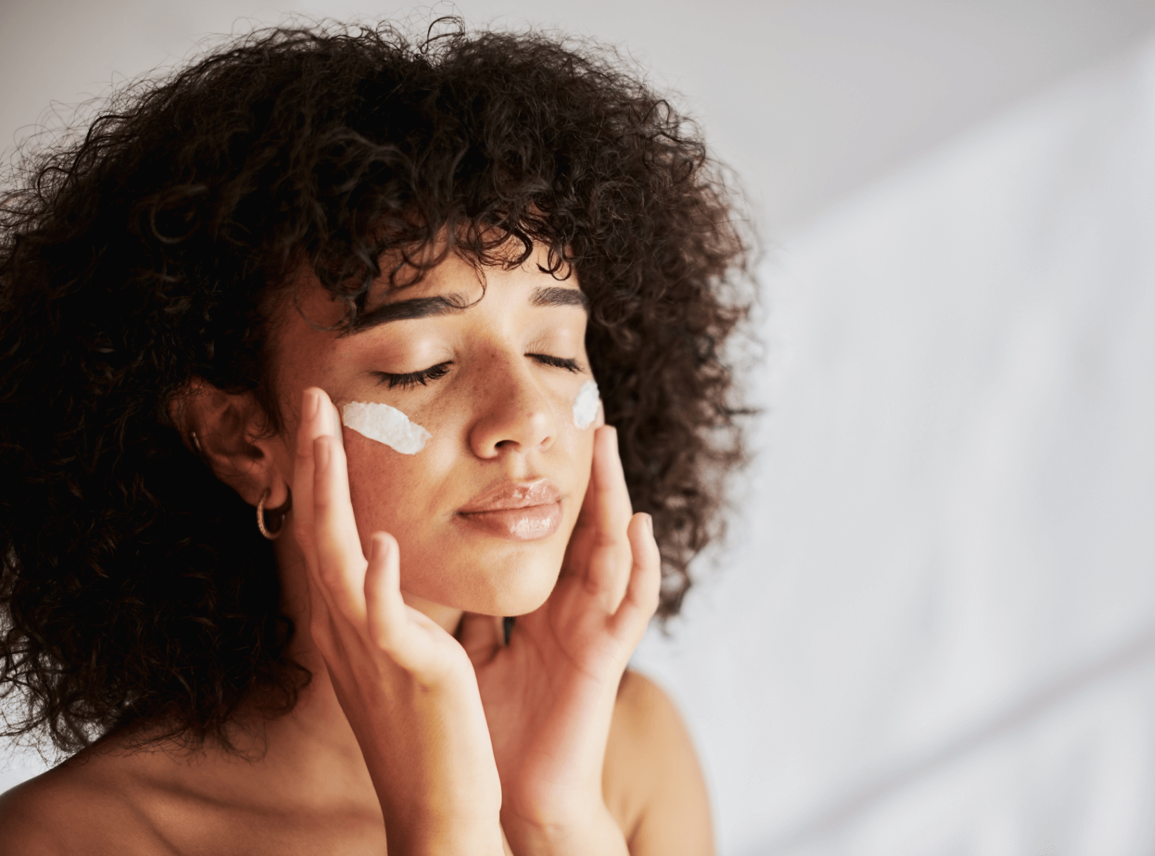 woman applying cosmetics on her face